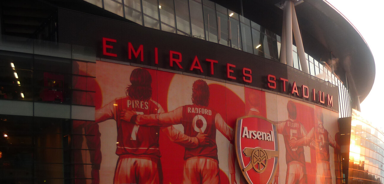 Emirates Stadium exterior with the Arsenal crest on the mural, where the Farke Leeds Arsenal match is played